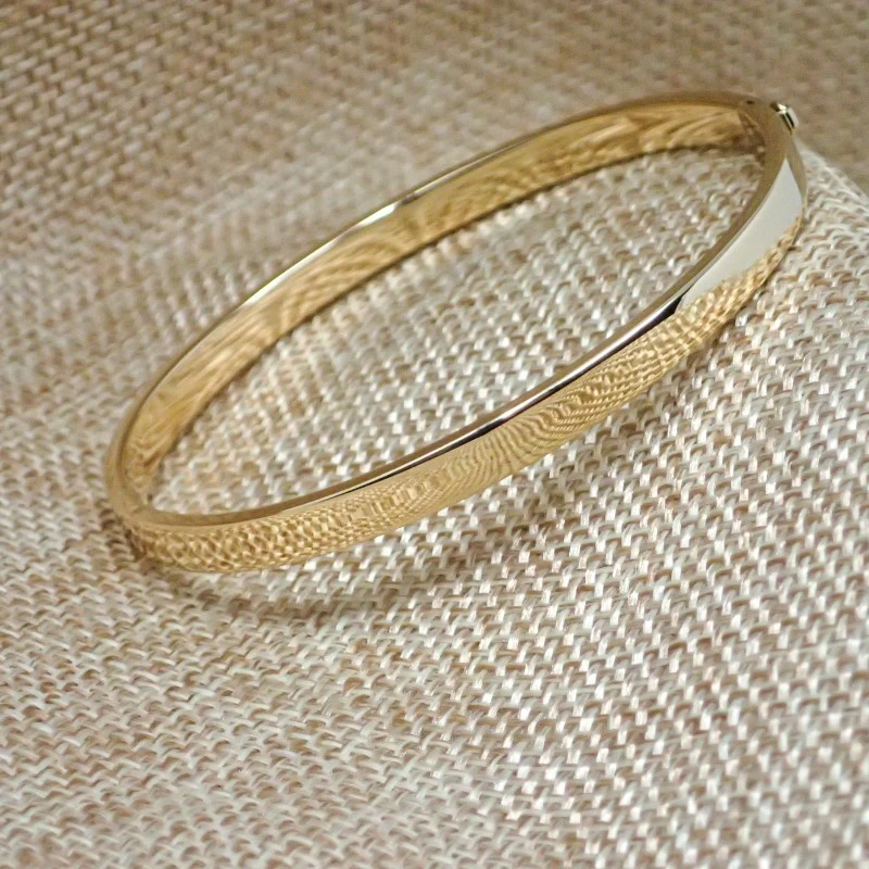 Pulsea rígida oro 18k brazalete mujer 60 mm. media caña lisa ancho 5